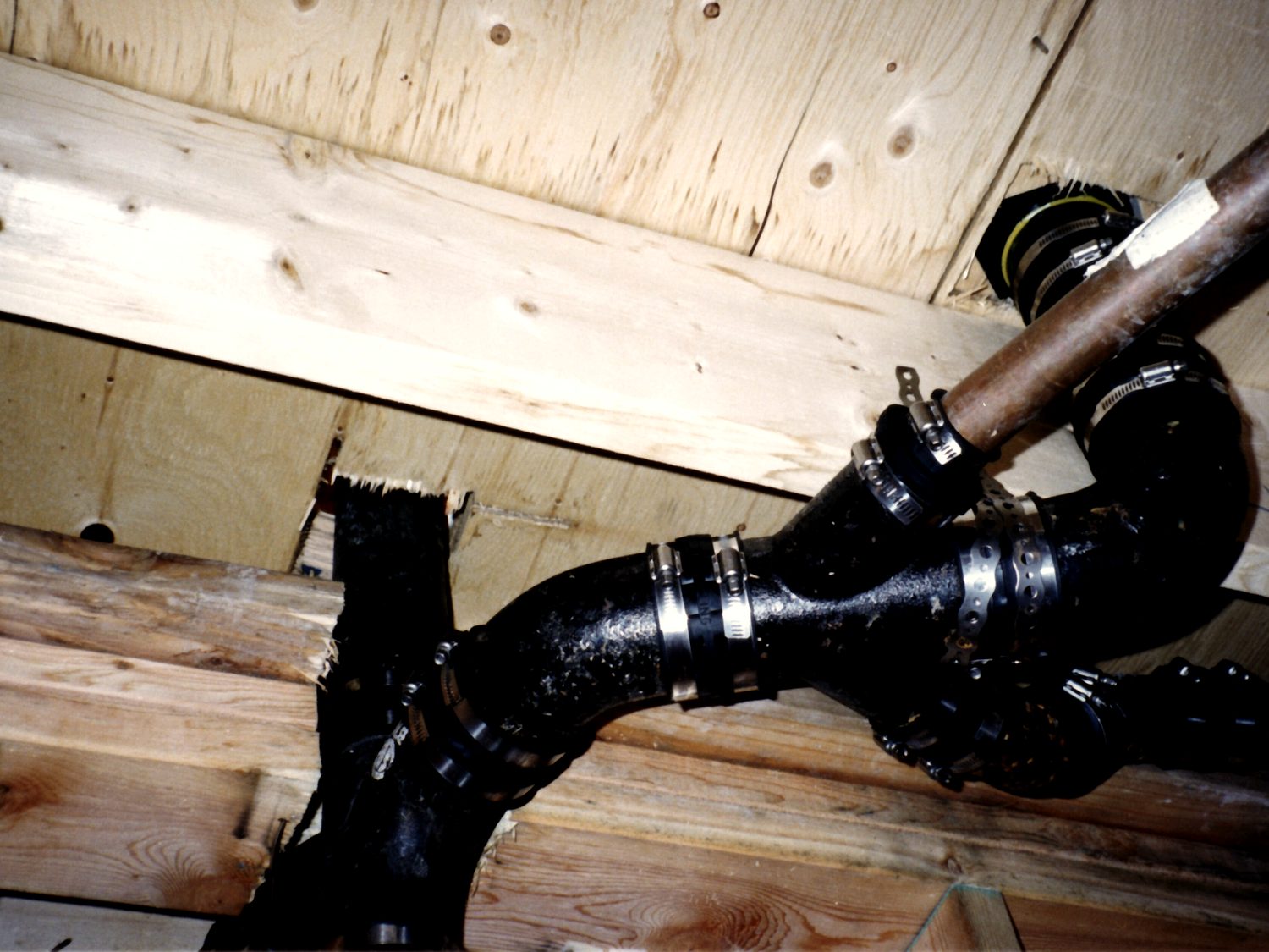 Cast iron and copper drain, waste and vent piping run through floor joists.