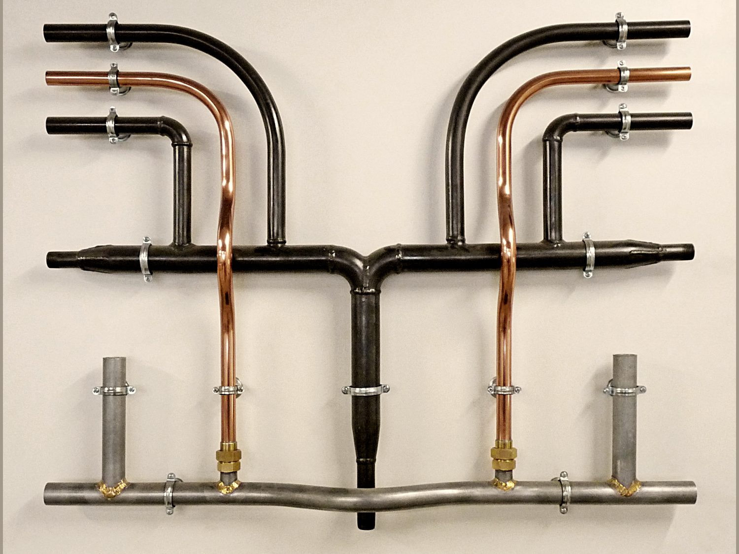 Copper, galvanized steel, and black steel pipe fittings laid out and assembled.